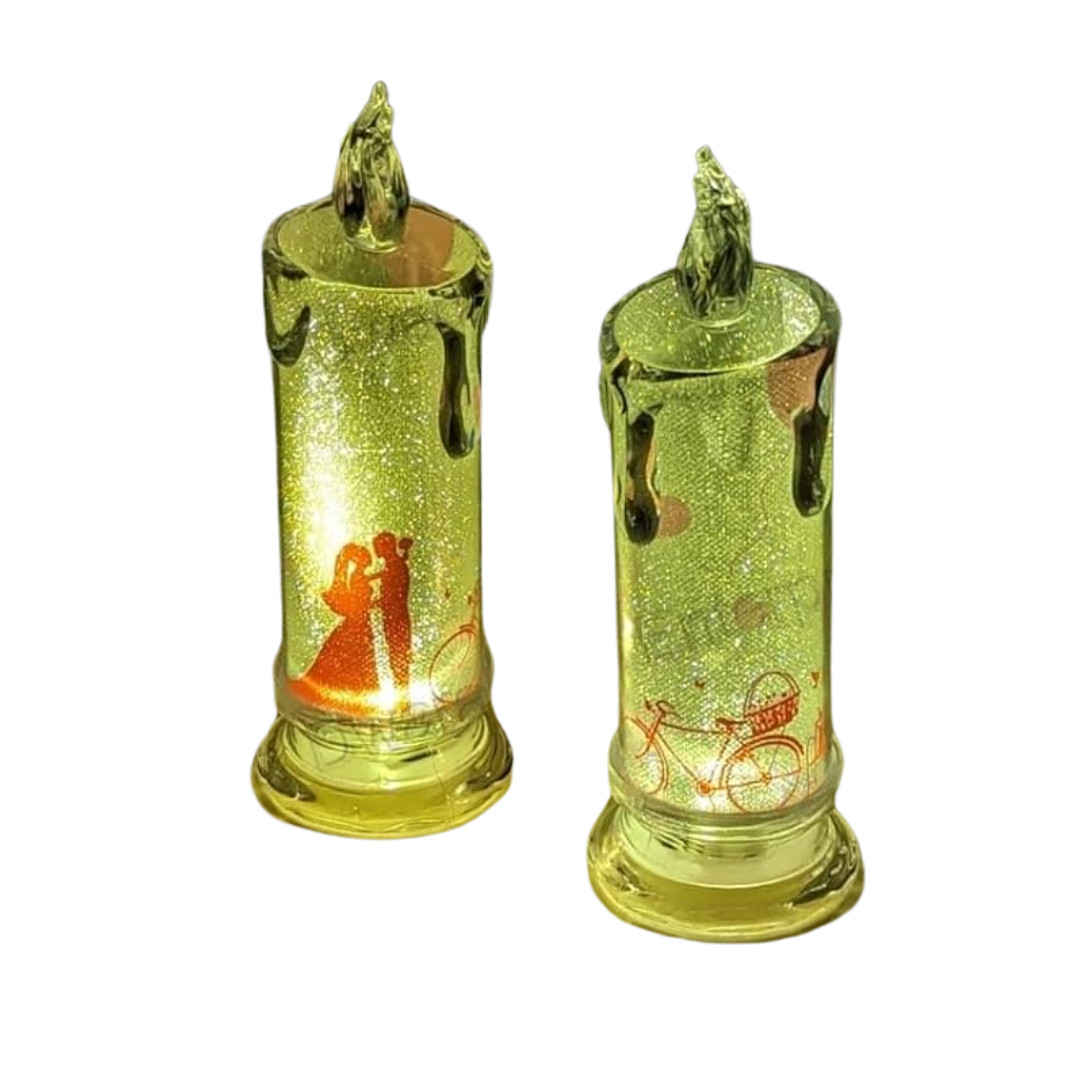 Two transparent crystal LED candles with glitter wax drip effect, displaying warm LED glow, placed on a white surface.