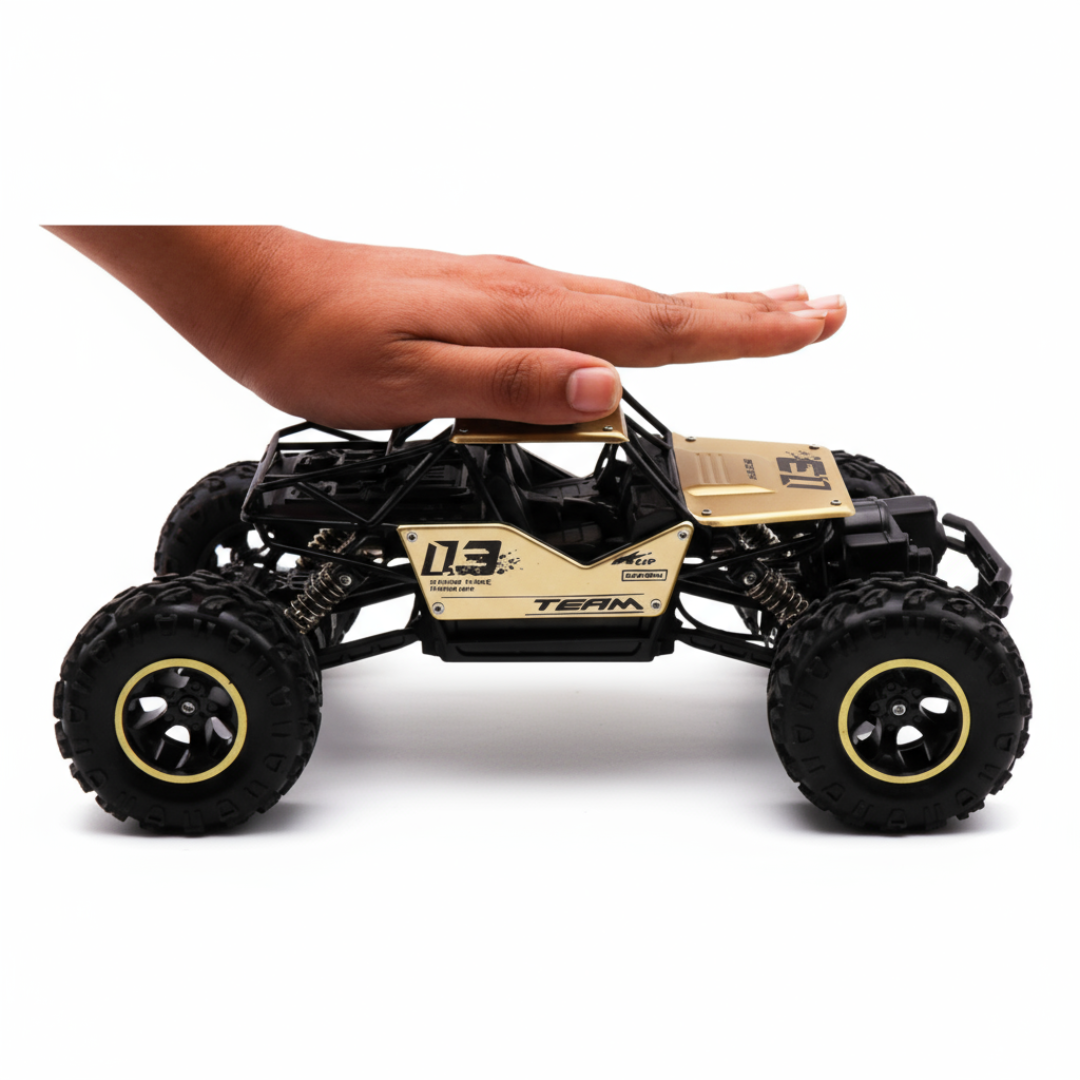 A hand holding a small remote-controlled metal RC car with a black and gold color scheme, designed for off-roading.