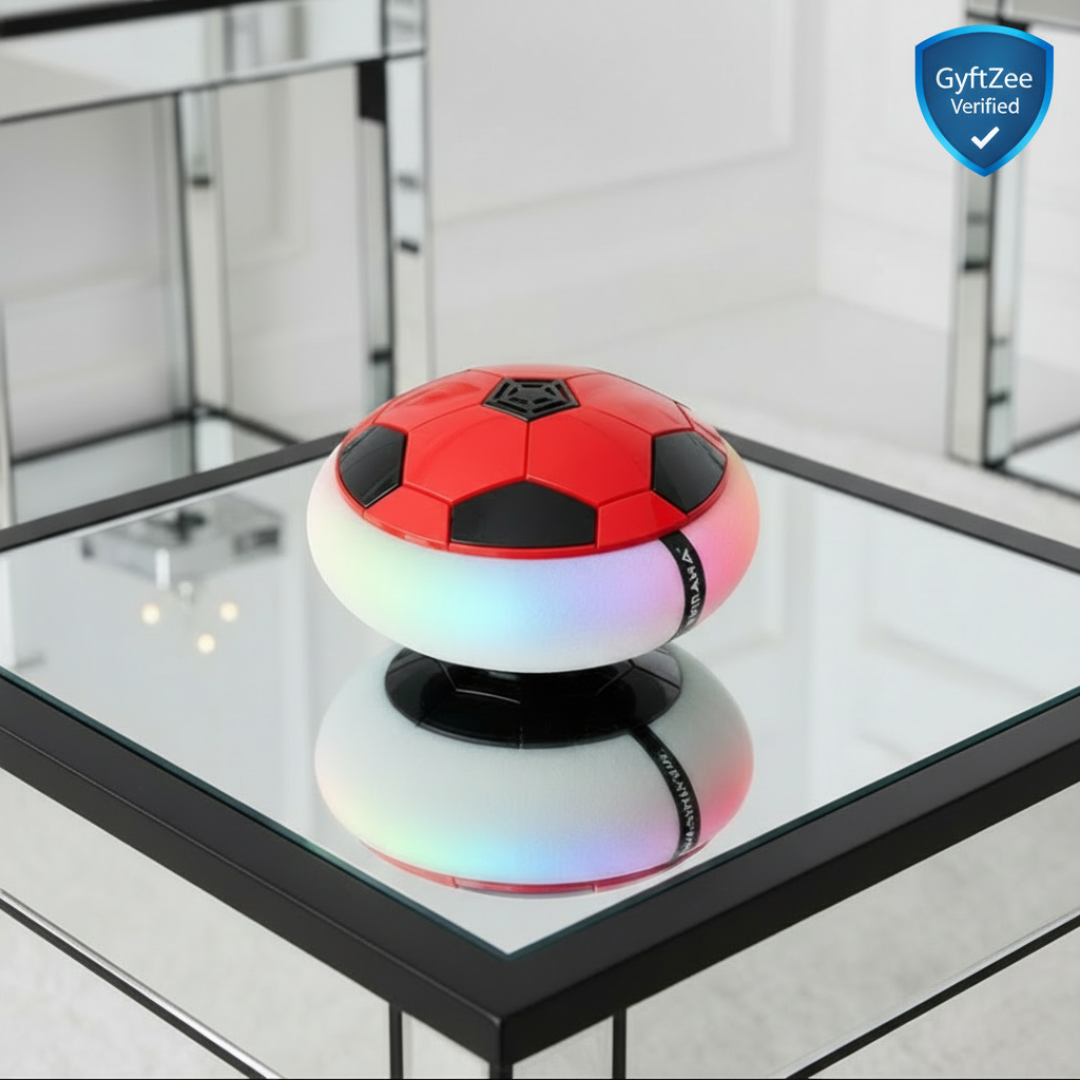 Red and black soccer ball-shaped object with colorful base on a reflective surface