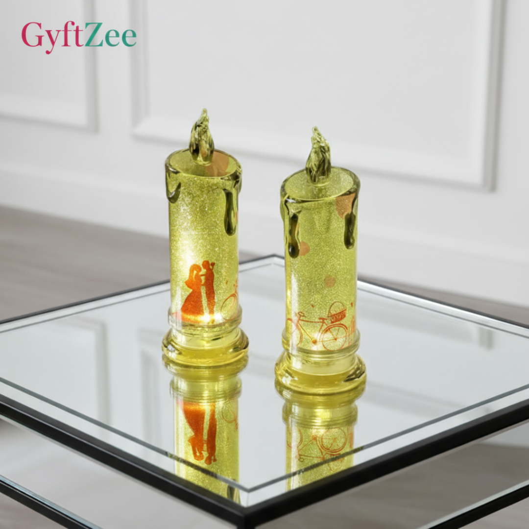 Two gold candle-shaped lights on a reflective surface with a neutral background
