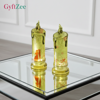 Two gold candle-shaped lights on a reflective surface with a neutral background