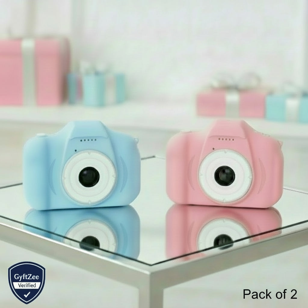 Two toy cameras, one blue and one pink, on a glass surface with a blurred background.