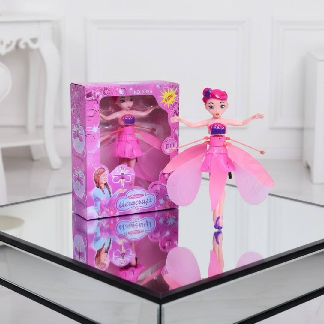 Pink fairy doll with open wings and packaging on a reflective surface