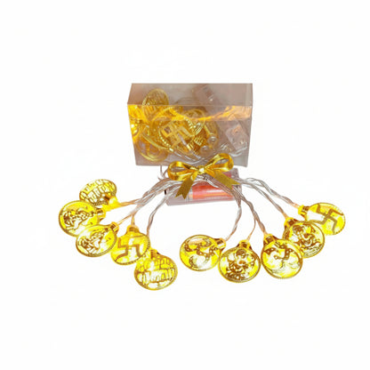 A set of decorative LED lights with a gold-colored finish, designed with intricate patterns, placed in front of a box, against a white background.