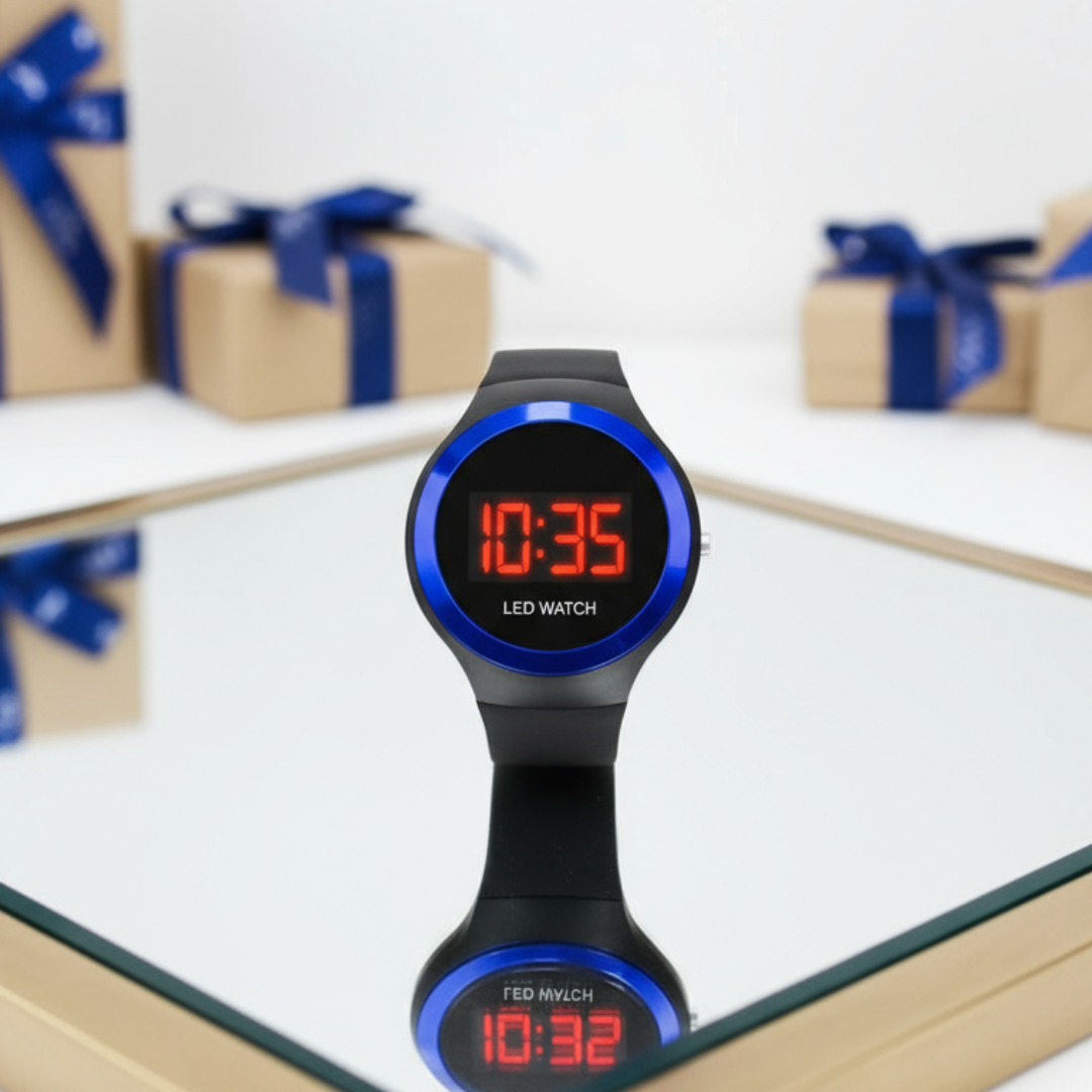Black LED watch with red digital display on a white surface with gift boxes in the background