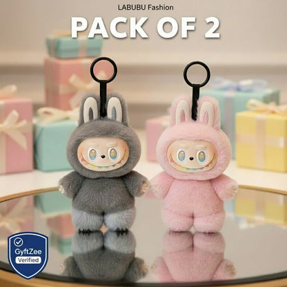 Two plush keychains, one gray and one pink, on a reflective surface with 'LABUBU Fashion' branding above.