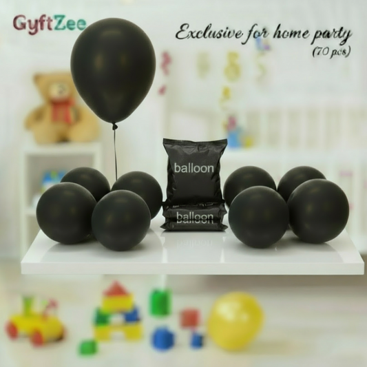 Black balloons and a bag labeled 'balloon' on a white surface with a blurred background.