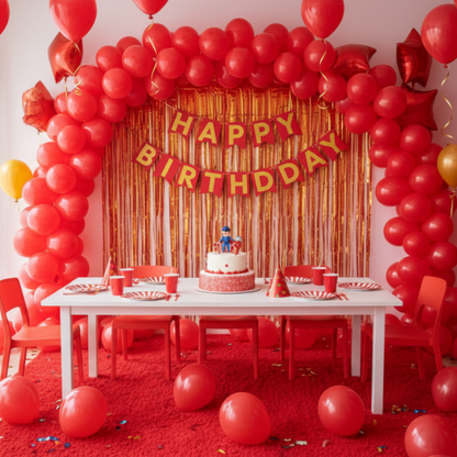 Birthday party setup with red balloons, a cake, and 'Happy Birthday' banner.