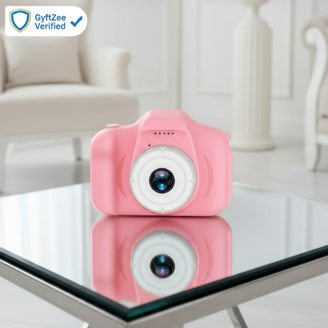 Pink toy camera on a glass table with a blurred indoor background