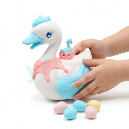 Toy swan with a baby swan inside, held by a hand on a white background
